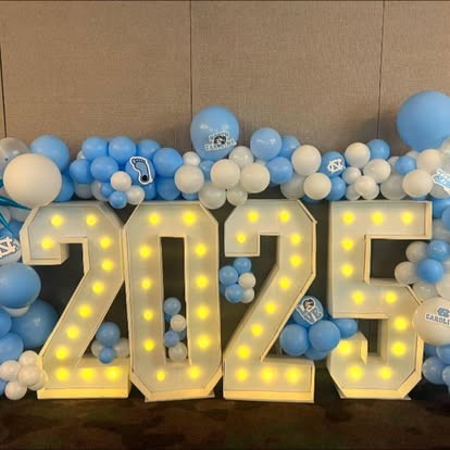 2025 light-up marquee numbers with Carolina blue and white balloon garland for a graduation celebration